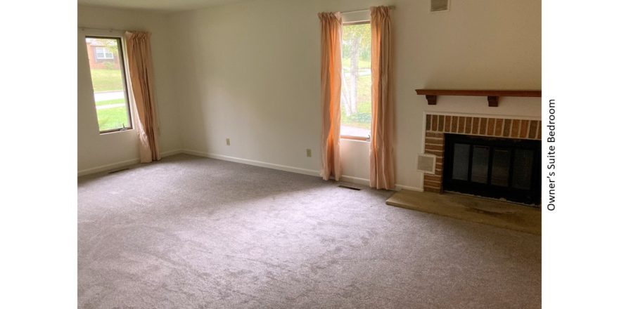 Owner's suite bedroom with gas fireplace and large windows