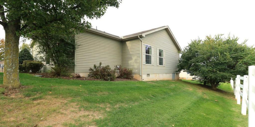 Exterior rear of home with pastel green siding and large yard