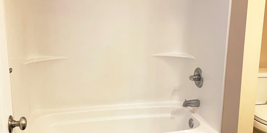 a bathroom with a white bath tub sitting next to a sink