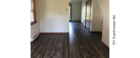 an empty living room with hard wood floors