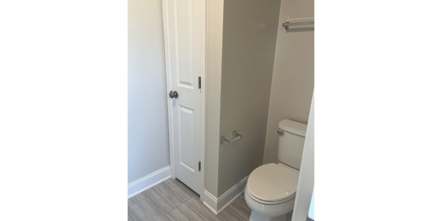 a white toilet sitting next to a bathroom closet