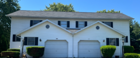a white two story duplex with black shutters