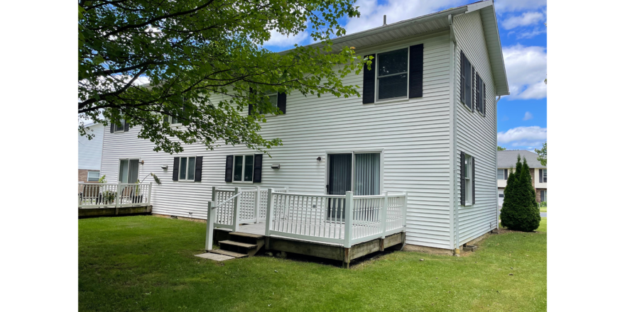 white duplex with black shutters and two decks