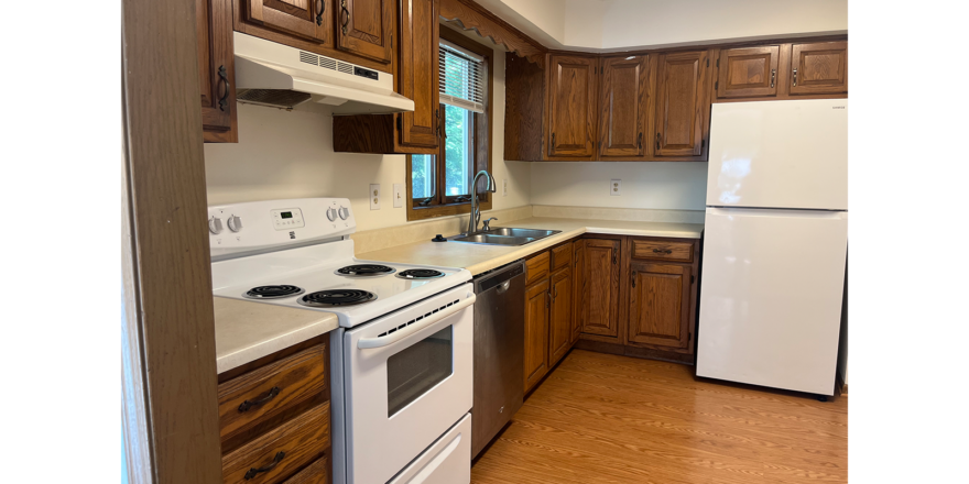 a kitchen with white appliances and wooden cabinets