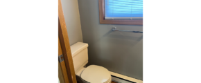 a bathroom with a toilet and a window