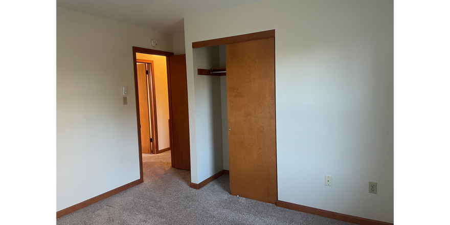 an empty room with two open doors in it