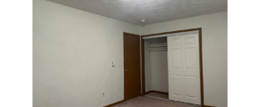 an empty room with a closet and a door