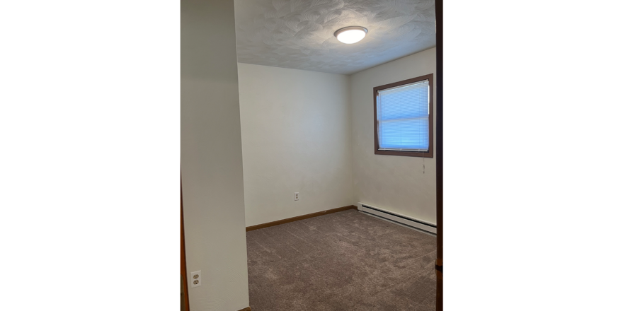 an empty room with carpet and a window