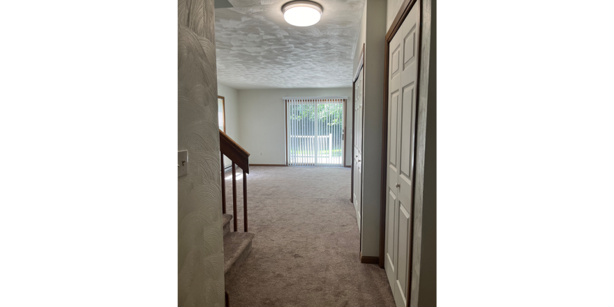 a hallway leading to a door and a window