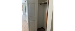 an empty closet with a door open
