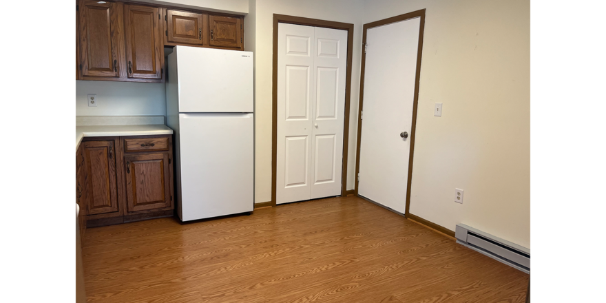 an empty kitchen with a refrigerator and a stove