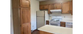 a kitchen with white appliances and wooden cabinets