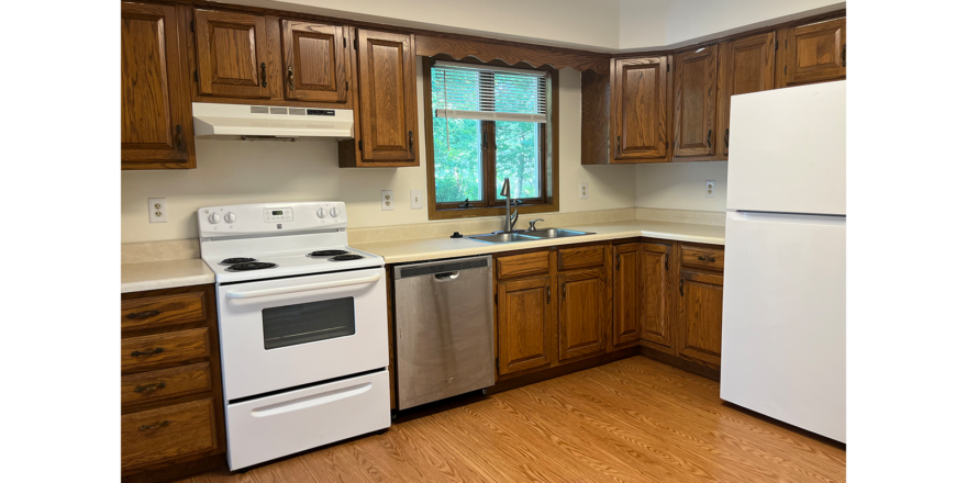 a kitchen with wood cabinets and white appliances