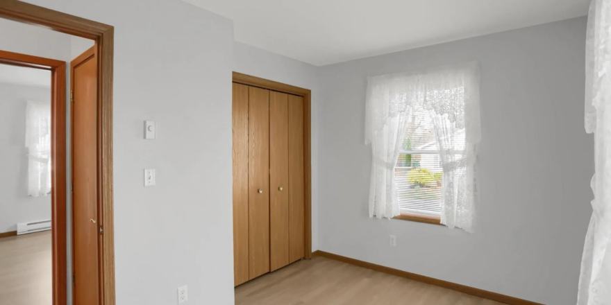 an empty room with wood floors and white walls