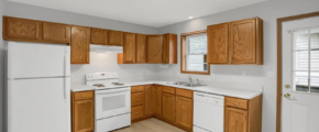 a kitchen with white appliances and wooden cabinets