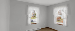 a empty room with two windows and a radiator