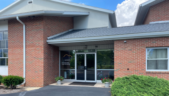 brick building with glass windows and a parking lot in front of it
