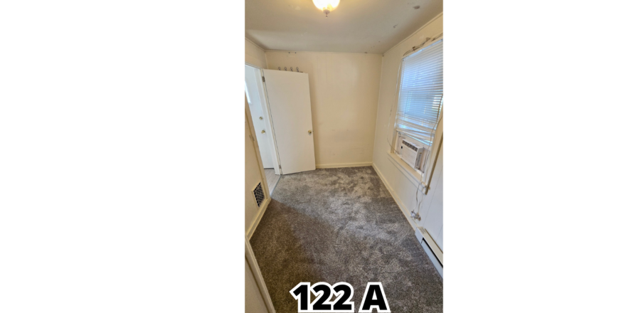 an empty room with carpet and a door