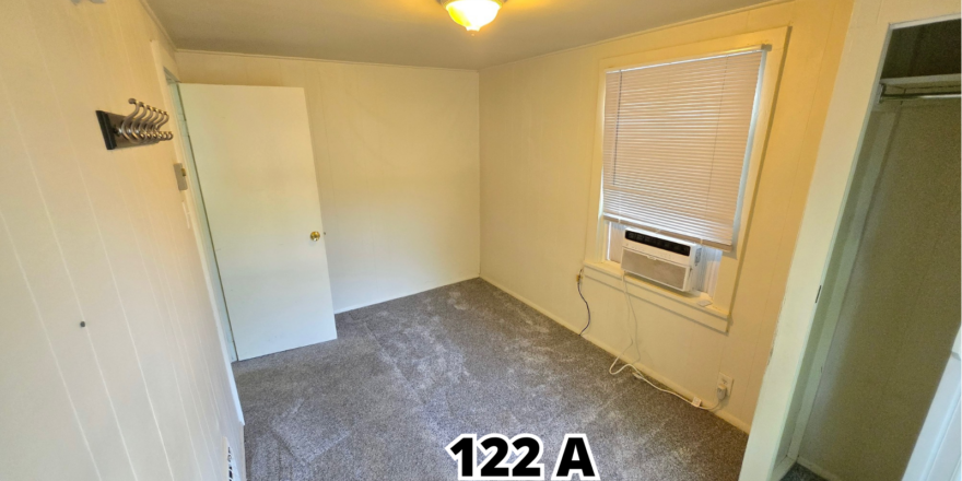 an empty room with a window and a radiator