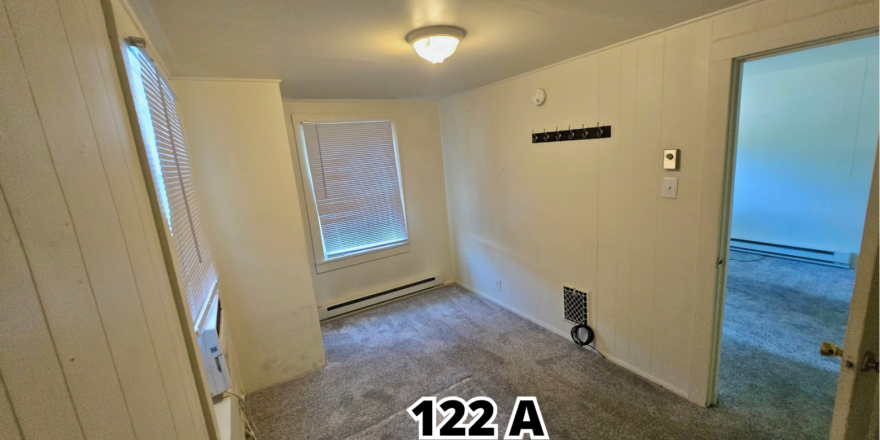 an empty room with a door leading to another room