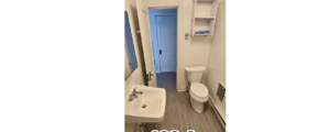 a bathroom with a toilet, sink, and mirror