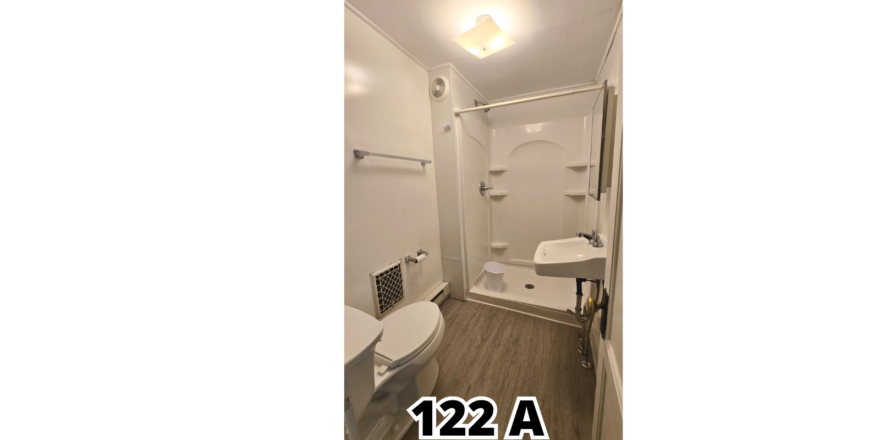 a bathroom with a toilet, sink, and shower