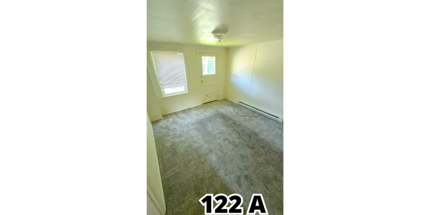 an empty room with a door and a window