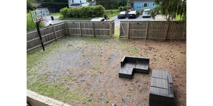 a backyard with a wooden bench and a wooden fence