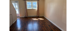 an empty room with wood floors and a door