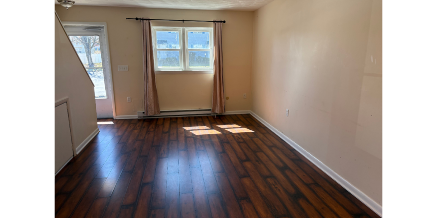 an empty room with wood floors and a door