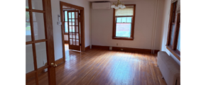 an empty room with wooden floors and windows