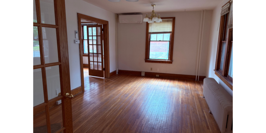 an empty room with wooden floors and windows