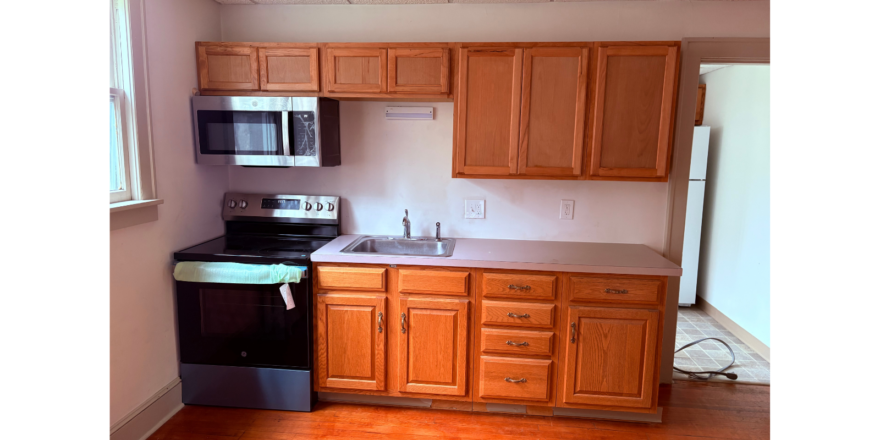 a kitchen with wooden cabinets and black appliances