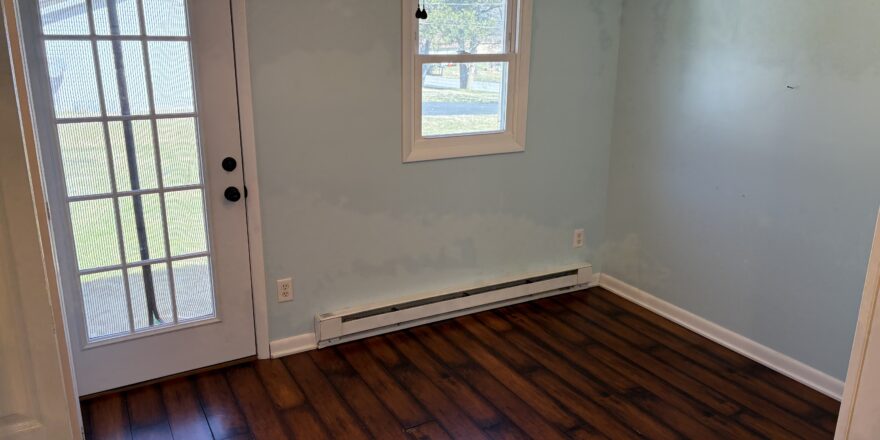 an empty room with a ceiling fan and wooden floors