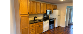 a kitchen with wooden cabinets and black counter tops