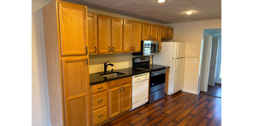 a kitchen with wooden cabinets and black counter tops