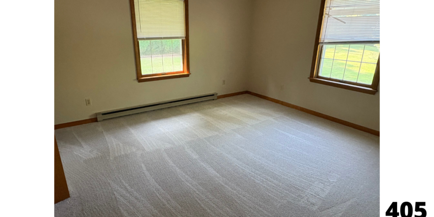 an empty room with two windows in it