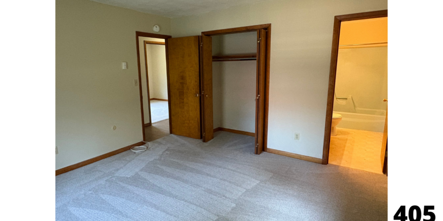 an empty room with a door and a closet