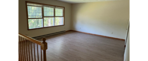 an empty room with a wooden railing and a window