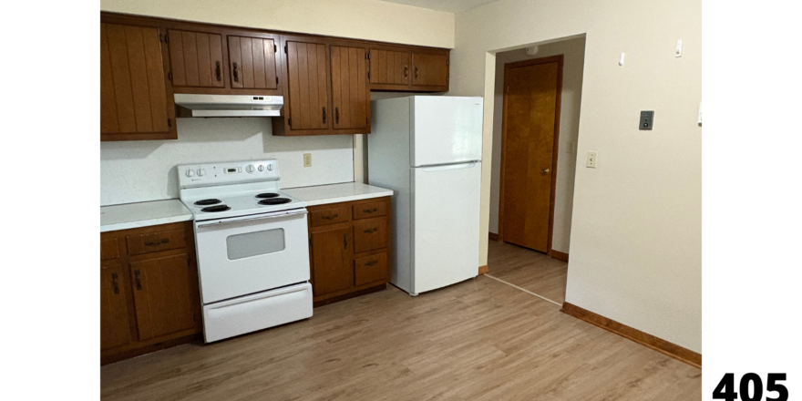 a kitchen with white appliances and wooden cabinets