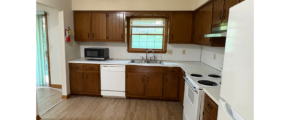 a kitchen with wood floors and white appliances