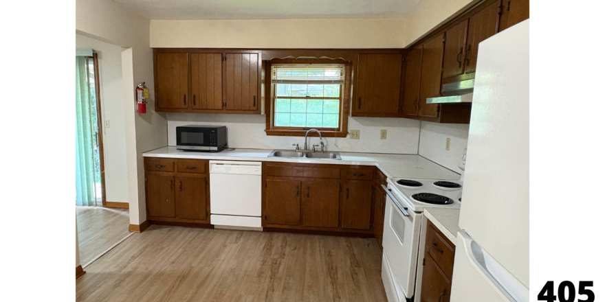 a kitchen with wood floors and white appliances