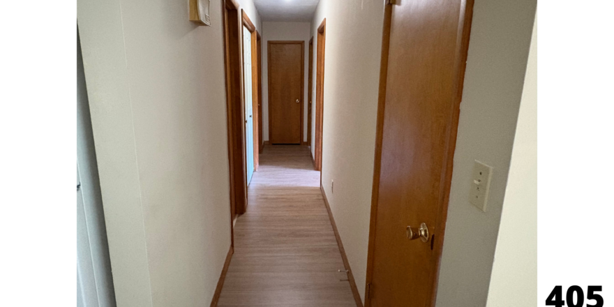 a long hallway with a door and a light on