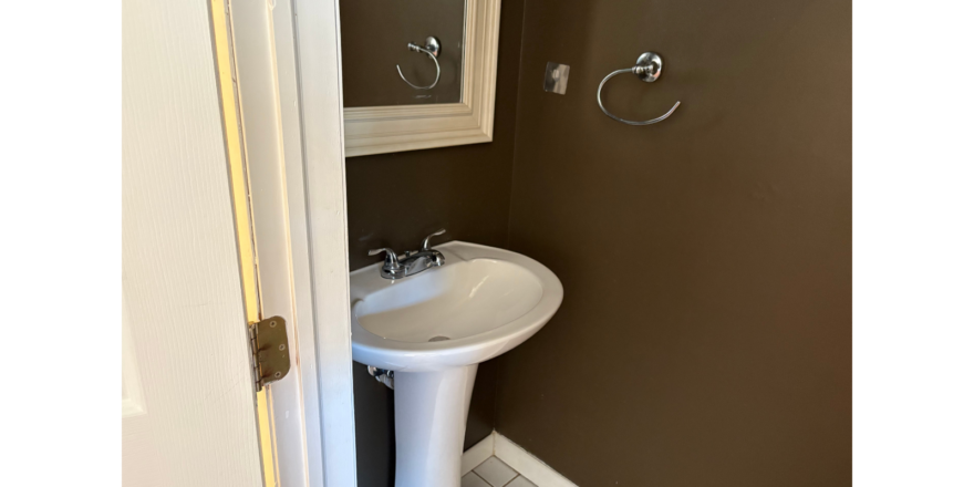 a bathroom with a pedestal sink and mirror