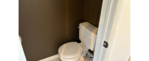a white toilet sitting in a bathroom next to a door