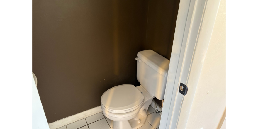 a white toilet sitting in a bathroom next to a door