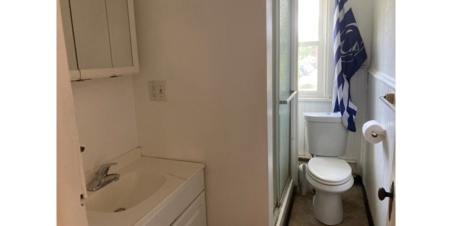 a bathroom with a toilet, sink and mirror