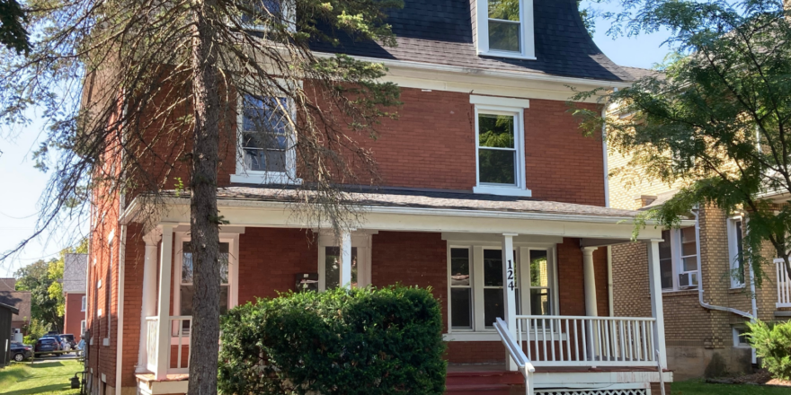 a red brick house with a white porch