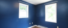 a empty room with blue walls and wood floors