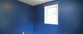 an empty room with blue walls and a window